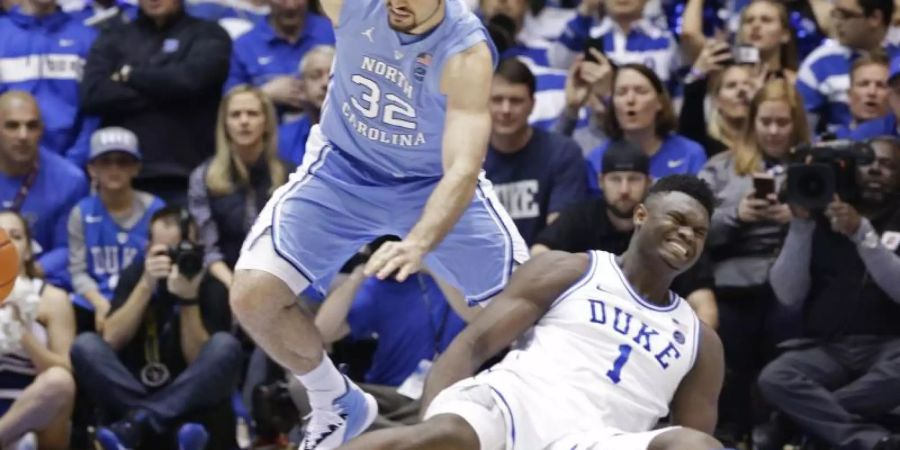 Zion Williamson (r) von Duke University stürzt bei einer Aktion mit North Carolinas Luke Maye während eines NCAA College-Basketballspiels. Foto: Gerry Broome/AP/dpa