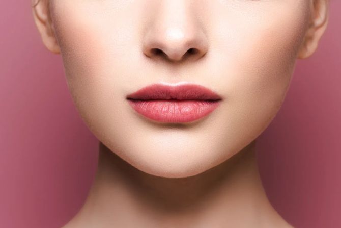 Frau mit rosigen Lippen vor rosa.