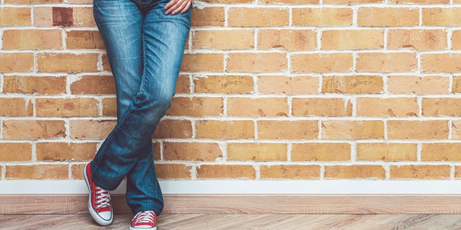 Frau mit Bootcut Jeans und Turnschuhen