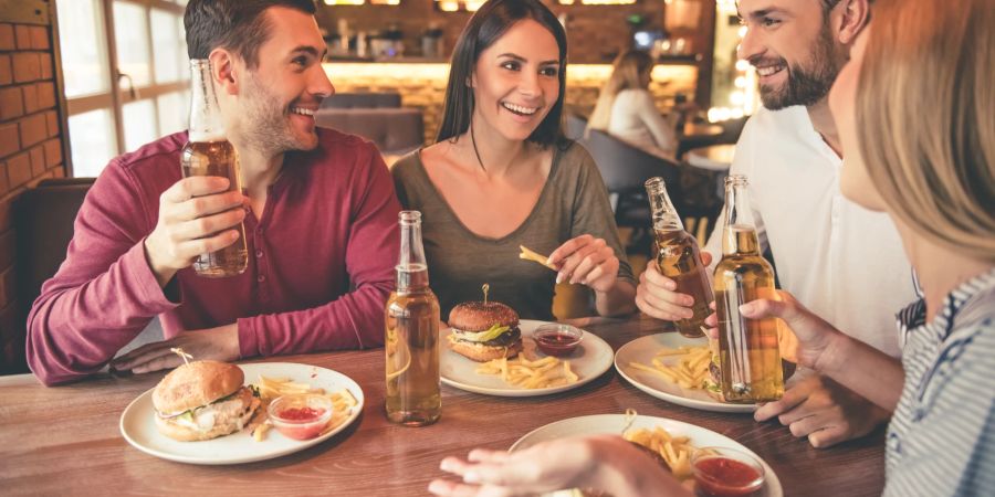 Freunde essen Burger in Restaurant