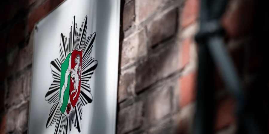 Das Wappen der Polizei Nordrhein-Westfalen hängt an der Wand eines Polizeipräsidium.