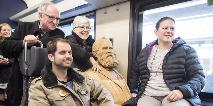 Die Schweiz ist eine Nation von Bahnfahrenden. Passagiere posieren mit einer Statue des Eisenbahnpioniers Alfred Escher. (Archivbild) Zug