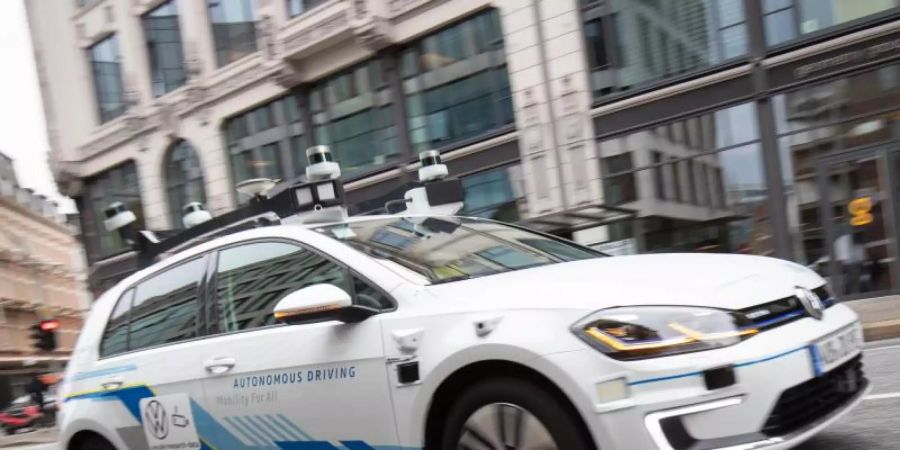 Ein Elektro-Golf, bestückt mit Laserscannern, Kameras, Ultraschallsensoren und Radar für vollautomatisches Fahren, ist bei einer Testfahrt in der Innenstadt unterwegs. Foto: Christian Charisius/dpa