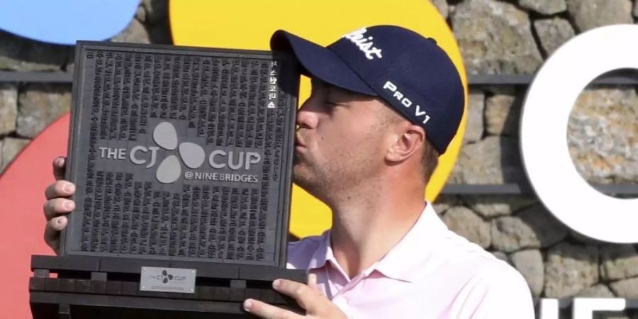 Golfstar Justin Thomas küsst auf der südkoreanischen Urlaubsinsel Jeju die Siegertrophäe. Foto: Chun Jin-Hwan/Newsis/dpa