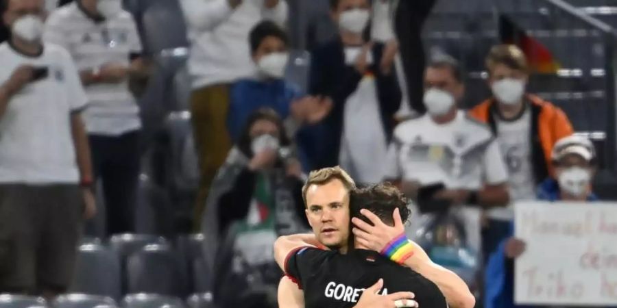 Leon Goretzka und Torhüter Manuel Neuer umarmen sich nach dem Spiel. Foto: Federico Gambarini/dpa