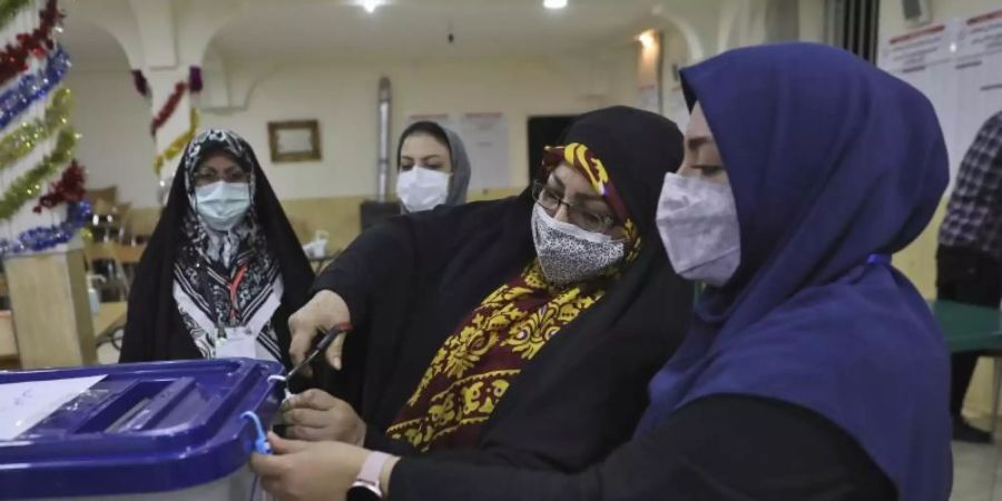 Wahlhelferinnen öffnen eine Wahlurne in einem Wahllokal in Teheran. Das iranische Innenministerium hat in der Nacht mit der Stimmenauszählung der Präsidentenwahl begonnen. Foto: Vahid Salemi/AP/dpa