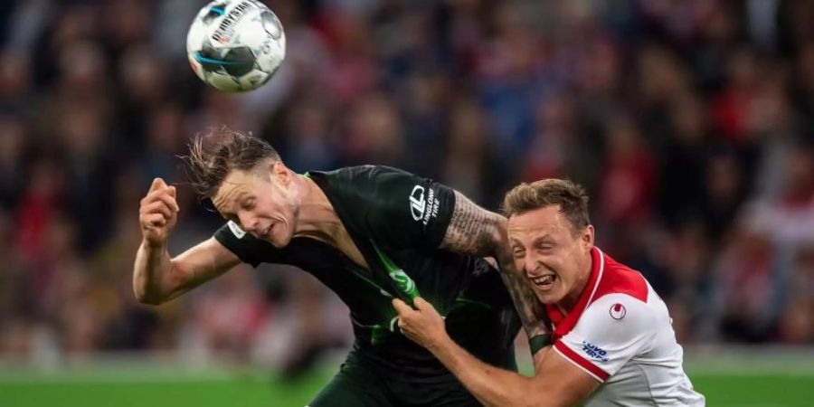 Düsseldorfs Robin Bormuth (r) und Wolfsburgs Wout Weghorst kämpfen um den Ball. Foto: Marius Becker