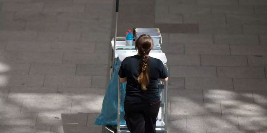 Eine Gebäudereinigerin schiebt einen Wagen mit Reinigungsmitteln. Etwa jeder fünfte Vollzeitbeschäftigte arbeitet für einen Niedriglohn. Foto: Sebastian Kahnert