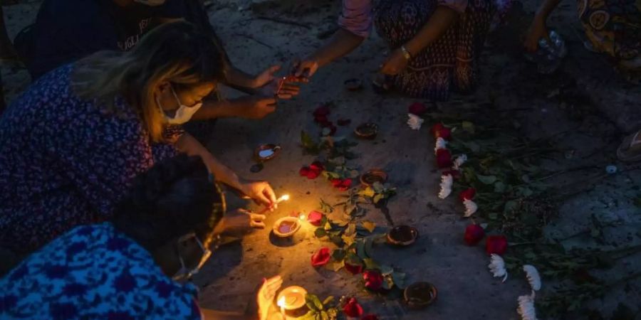 Frauen zünden während einer Zeremonie in Yangon Kerzen an, um den Opfern zu gedenken, die bei Massendemonstrationen gegen die Junta getötet wurden. Foto: Uncredited/AP/dpa