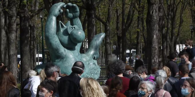 Menschen laufen an einer Katzen-Skulptur des belgischen Künstlers Philippe Geluck auf der Pariser Champs-Élysées vorbei. Avenue des Champs-Élysées