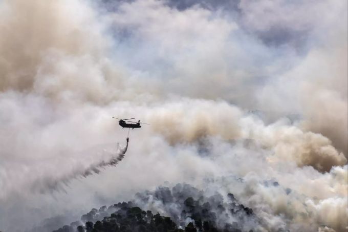 Ein Militärhubschrauber wirft Wasser über einem Wald in der Nähe des Dorfes Schinos, Korinth, Griechenland, ab. APTOPIX Greece Wildfire