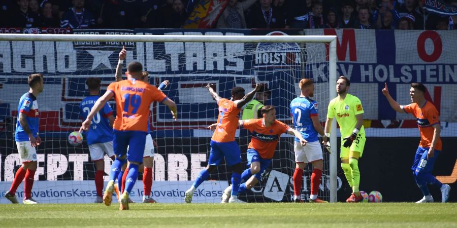 Darmstadts Jannik Müller (M) und seine Mitspieler jubeln nach Müllers Treffer zum 1:0 für den Tabellenführer.