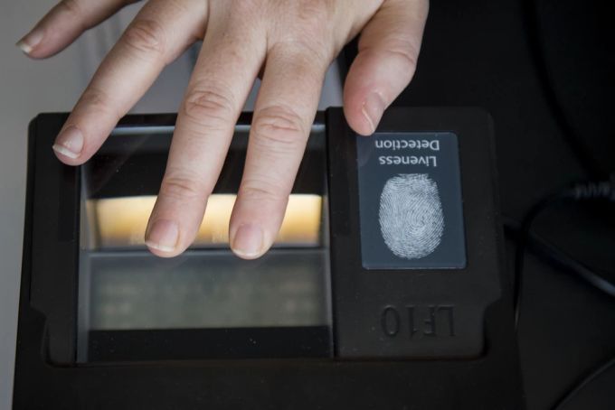 Eine Mitarbeiterin der Kapo Zürich demonstriert die Möglichkeit der Sicherheitskontrolle mit einem Fingerabdruck-Scanner an einer Medienkonferenz. fingerabdruck