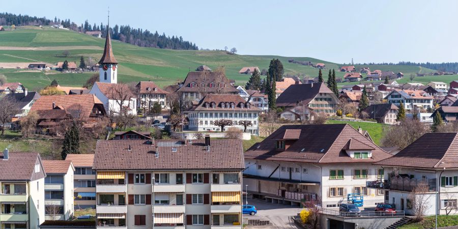 Blick auf Biglen mit der evangelisch-reformierten Kirche, dem Gemeindehaus und dahinter dem Bären.