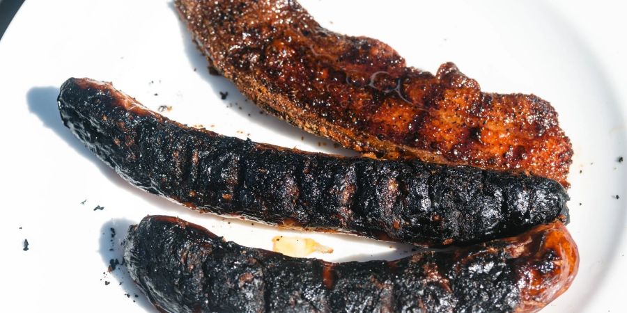 Eindeutig verkohlte Bratwürste, die nicht mehr gegessen werden sollten: Die schwarze Kruste enthält krebserregende Stoffe.
