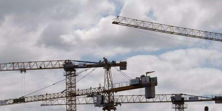 Baukräne stehen auf einer Baustelle. «Die Zeichen stehen eindeutig auf Erholung», teilte das DIW mit. Foto: Jörg Carstensen/dpa