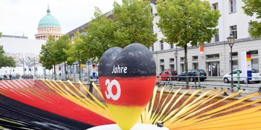 Ein schwarz-rot-goldenes Herz steht während des Eröffnungstages der «EinheitsExpo» in Brandenburgs Landeshauptstadt. Foto: Soeren Stache/dpa-Zentralbild/dpa