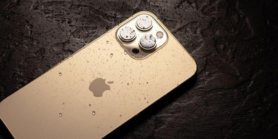 iPhone 15 Wassertropfen schwarzer Tisch