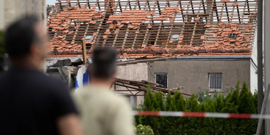 Anwohner blicken auf das beschädigte Dach eines Hauses in Lippstadt.