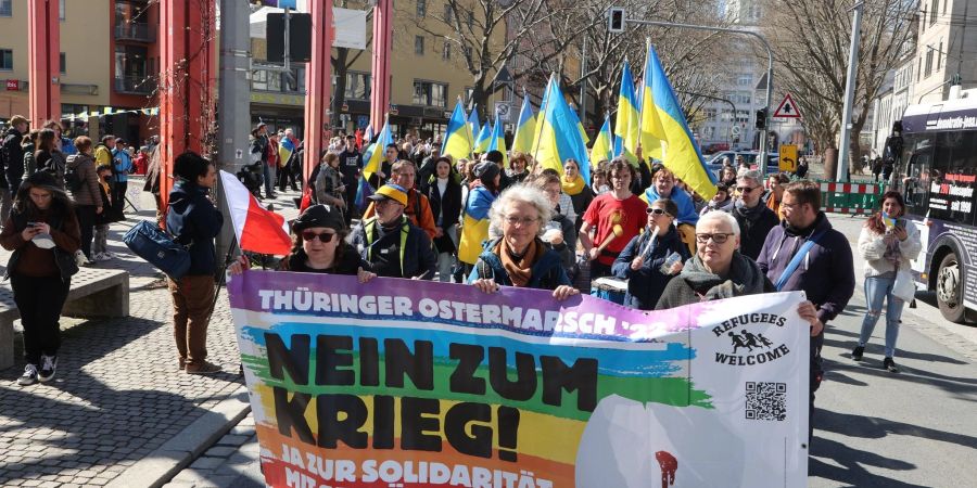 Teilnehmer eines Ostermarsches laufen in Jena nach einer Kundgebung auf dem Holzmarkt durch die Innenstadt.