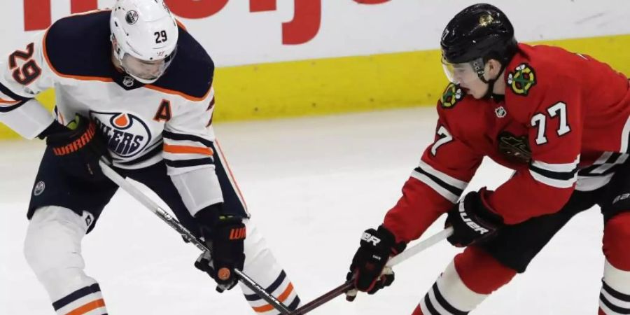 Kirby Dach (r) von den Chicago Blackhawks im Zweikapmf mit Leon Draisaitl von den Edmonton Oilers. Foto: Nam Y. Huh/AP/dpa