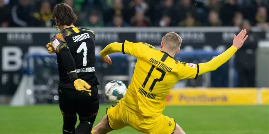 Yann Sommer kann vor dem heranbrausenden Haaland klären.