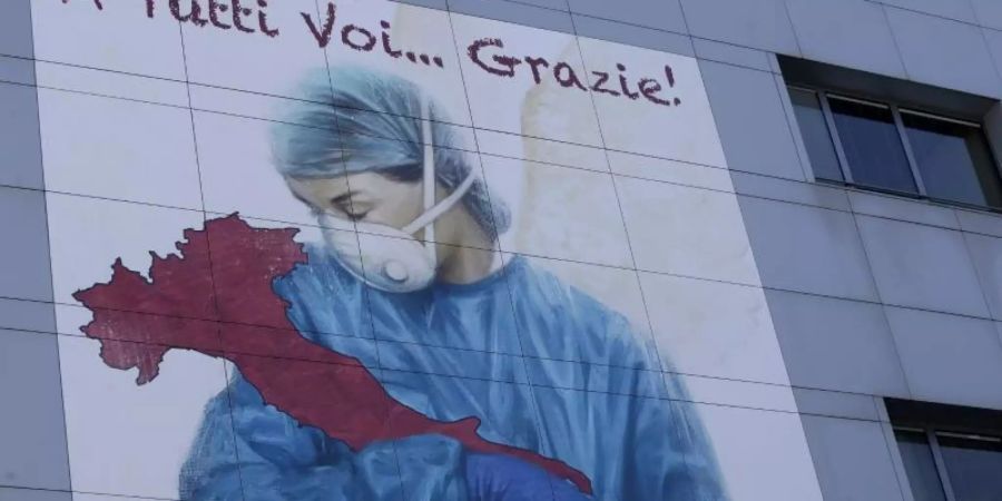 Eine riesige Zeichnung mit einer Krankenschwester an der Fassade des Krankenhauses Papa Giovanni XXIII. im italienischen Bergamo. Foto: Luca Bruno/AP/dpa