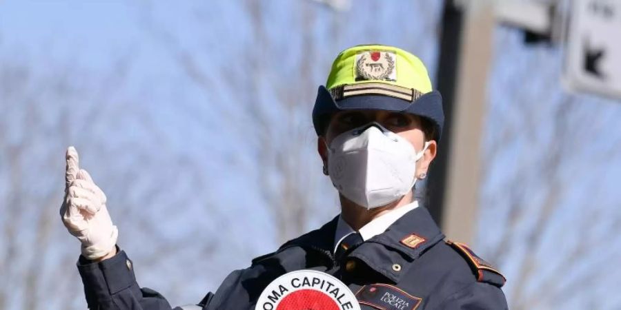 Eine Polizistin mit Mundschutz bei einer Strassenkontrolle in Rom. Foto: Alfredo Falcone/LaPresse via ZUMA Press/dpa