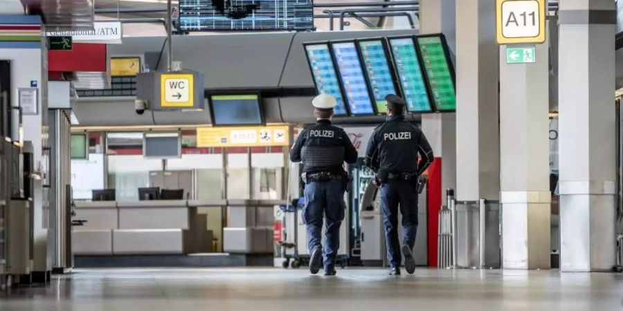 Polizisten patrouillieren am Flughafen Berlin-Tegel durch das Terminal. Foto: Michael Kappeler/dpa