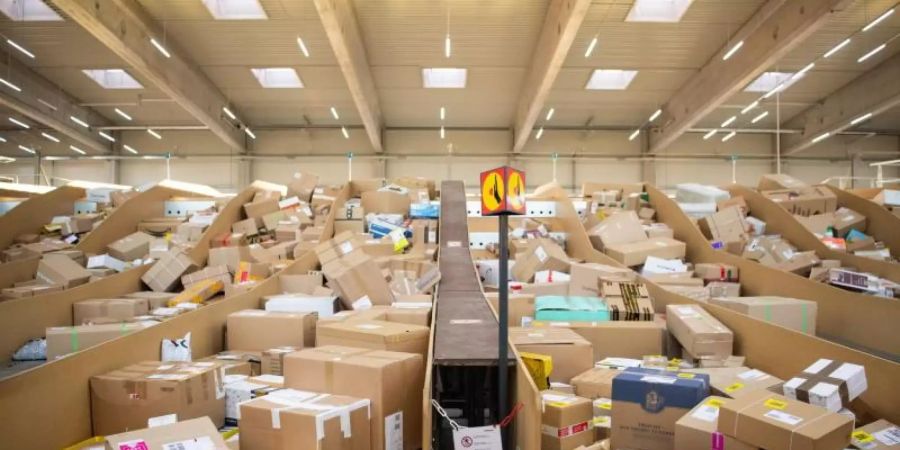 Pakete liegen in einem Paketzentrum der Deutschen Post. Für die Paketbranche ist der boomende Online-Handel ein dankbarer Trend. Foto: Tom Weller/dpa