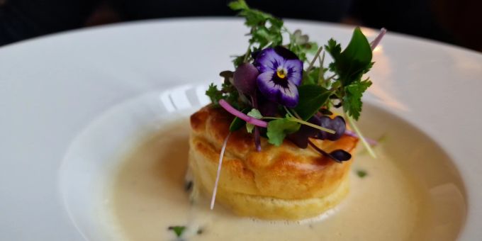 Florale Begrüssung: das Käsesoufflé in zwei Garstufen, Soubise-Sauce und junge Sprossen wird als vegetarische Vorspeise empfohlen. Restaurant