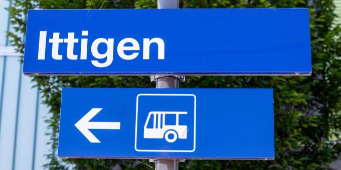 Stationsschild Ittigen mit Wegweiser zum Bus. Stationsschild Ittigen mit Wegweiser zum Bus.