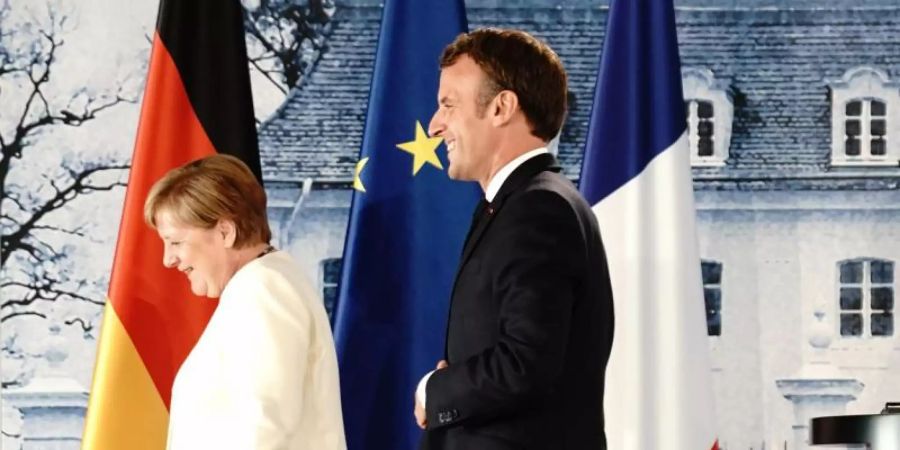 Angela Merkel und Emmanuel Macron verlassen die Pressekonferenz nach ihrem Treffen im Schloss Meseberg. Foto: Kay Nietfeld/dpa-Pool/dpa