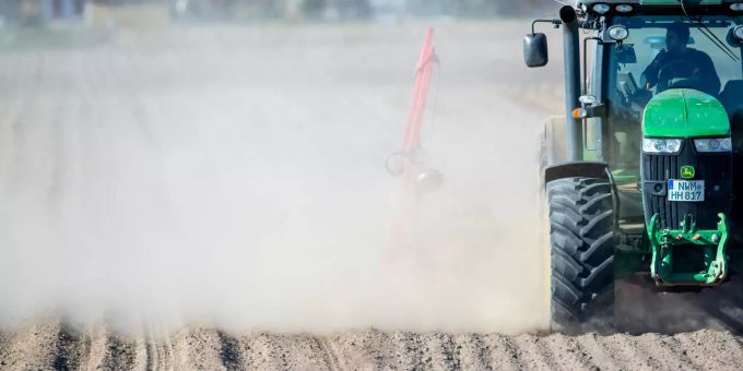 Ein Traktor zieht beim Maislegen eine Drillmaschine über einen Acker und wirbelt dabei eine Staubwolke auf. Trockenes Wetter herrscht seit Wochen. Kommt am Wochenende nun endlich Regen? Wetter Regen Trockenheit