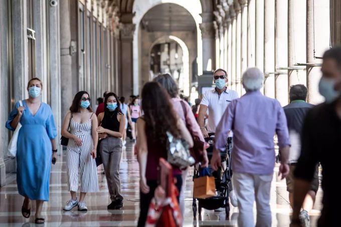 Passanten gehen mit Schutzmaske am Platz vor dem Mailänder Dom. Coronavirus - Italien
