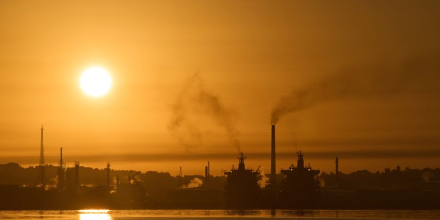 Rauch steigt aus den Schornsteinen einer Ölraffinerie in der Bucht von Havanna. Foto: Ramon Espinosa/AP/dpa