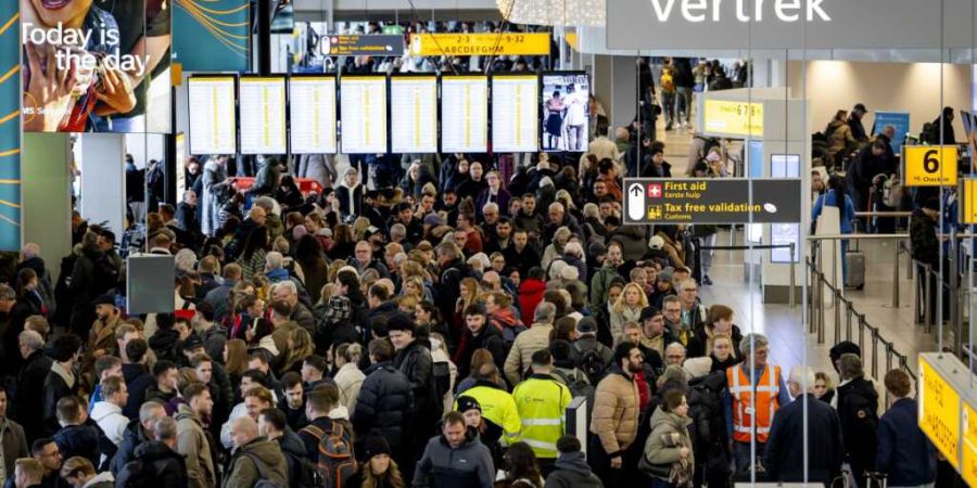 Reisende am Flughafen Schiphol werden vor Verspätungen und Flugausfällen aufgrund von Winterwetter und starkem Wind gewarnt. Foto: Koen Van Weel/ANP/dpa