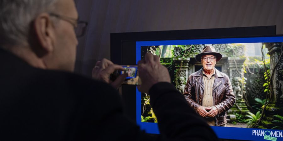 Bundespräsident Guy Parmelin macht an der Eröffnung der Phänomena in Dietikon mit seinem Smartphone ein Bild, welches ein KI-generiertes Bild von ihm als Indiana Jones zeigt. (Archiv...