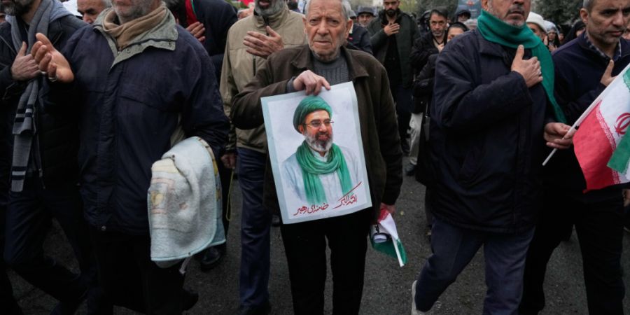 Ein Iraner hält ein Bild des neuen geistlichen Oberhauptes des Iran, Ajatollah Modschtaba Chamenei, beim Trauerzug für den getöteten iranischen Geheimdienstminister Ismail Chatib in ...