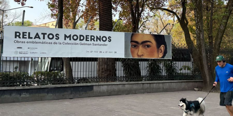 ARCHIV - Ein Mann joggt mit seinem Hund in Mexiko-Stadt an dem Plakat für eine Kunstausstellung mit Werken von Frida Kahlo vorbei. Foto: Andrea Sosa Cabrios/dpa/Archivbild