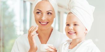 Mutter und Kind mit Handtüchern und Creme