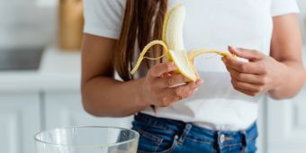 Frau schält Banane