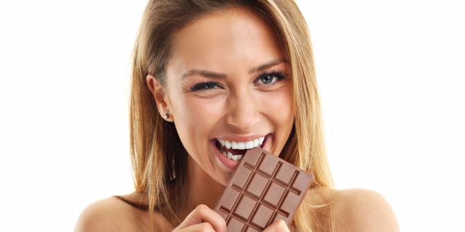 Frau beisst in Tafel Schokolade