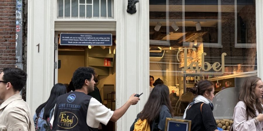 PRODUKTION - Menschen stehen vor einer Snackbar. Fabel-Friet im Zentrum der Stadt ist seit Jahren zum absoluten Hotspot für Touristen geworden. Foto: Annette Birschel/dpa