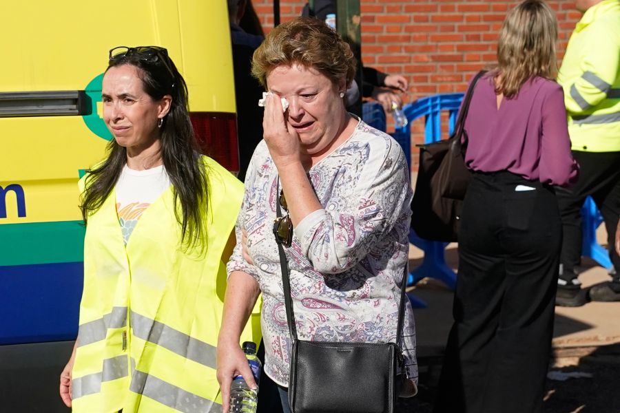 Eine Frau weint, eine Helferin in Warnweste steht ihr zur Seite.