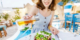 Frau isst griechischen Salat im Restaurant.