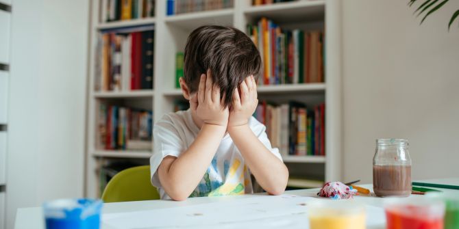 Kind hält sich Hände vors Gesicht