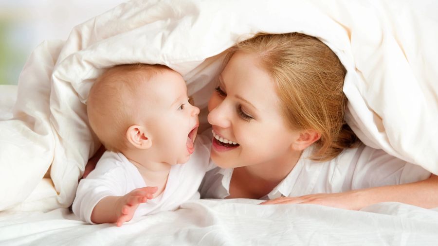 süsses Baby mit Mama unter der Decke