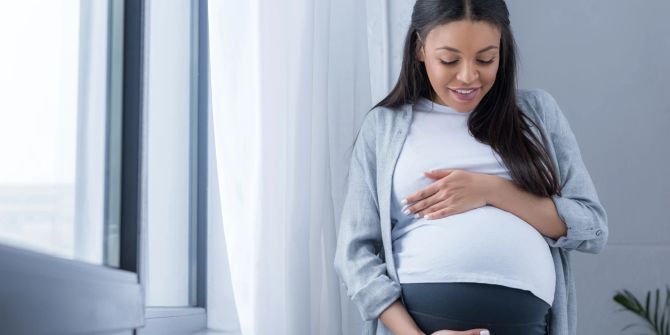 Schwangere Frau streichelt Bauch