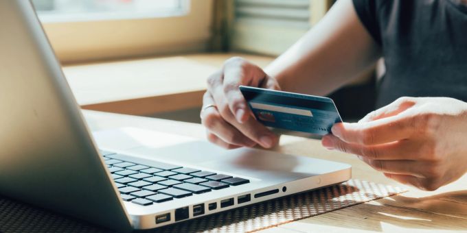 Um nicht auf Online-Betrüger hereinzufallen, sollte man aufpassen, wo man shoppt. Laptop, Kreditkarte